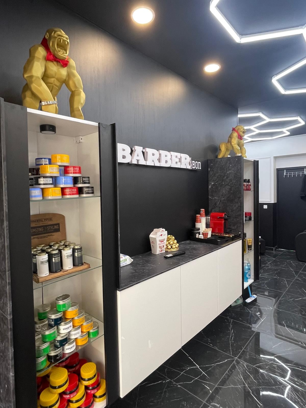 Comptoir d'accueil BARBER BON avec produits de coiffage et gorilles dorés